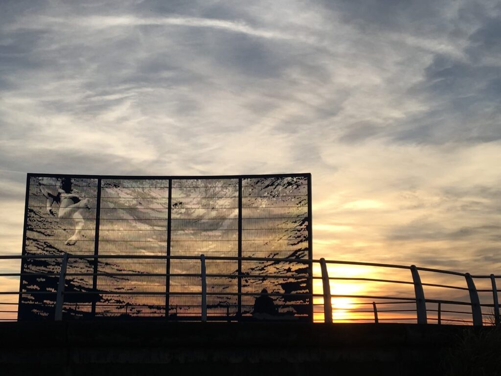 Sunset at New South Promenade, shining through the 'Waterwings' piece