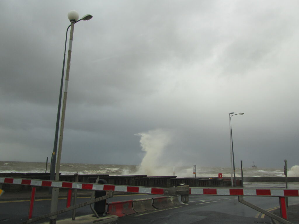 Road closure at Little Bispham, with the sea overtopping behind, in 2011