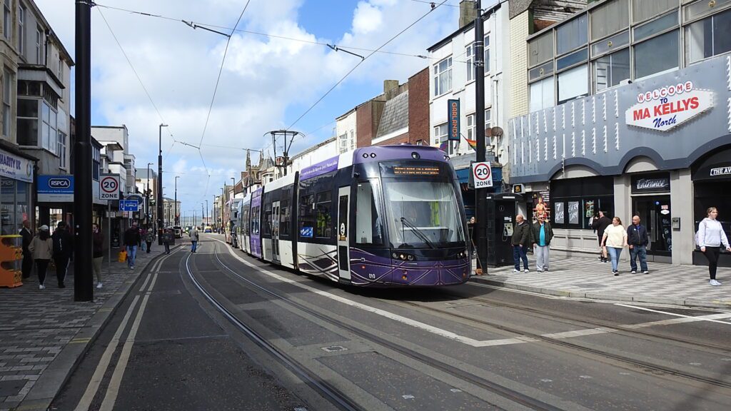 010 pauses at the junction with Dickson Road whilst checks are made to ensure the coordination between the tram signalling system and the traffic lights is fully working to the required safety standards. Note the public interest in this new mode of transport.